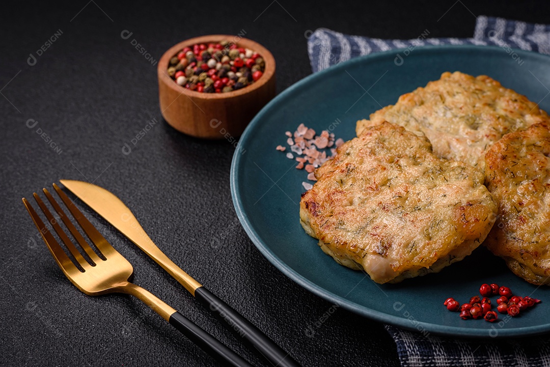 Deliciosas costeletas de peixe picado frito fresco com especiarias e ervas sobre um fundo escuro de concreto