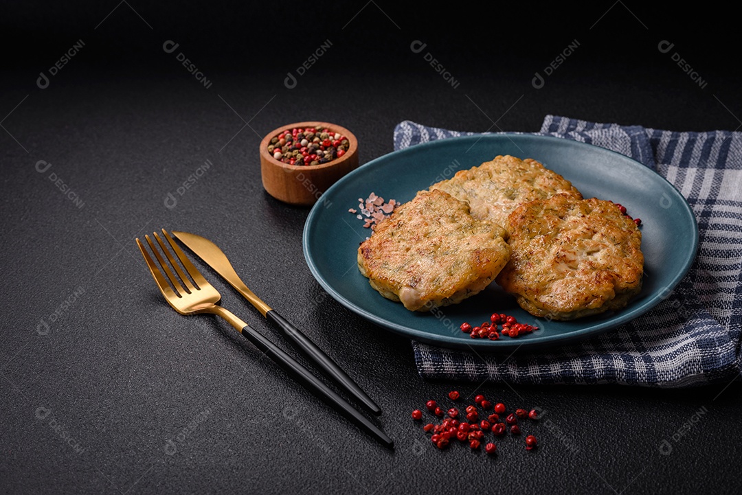 Deliciosas costeletas de peixe picado frito fresco com especiarias e ervas sobre um fundo escuro de concreto