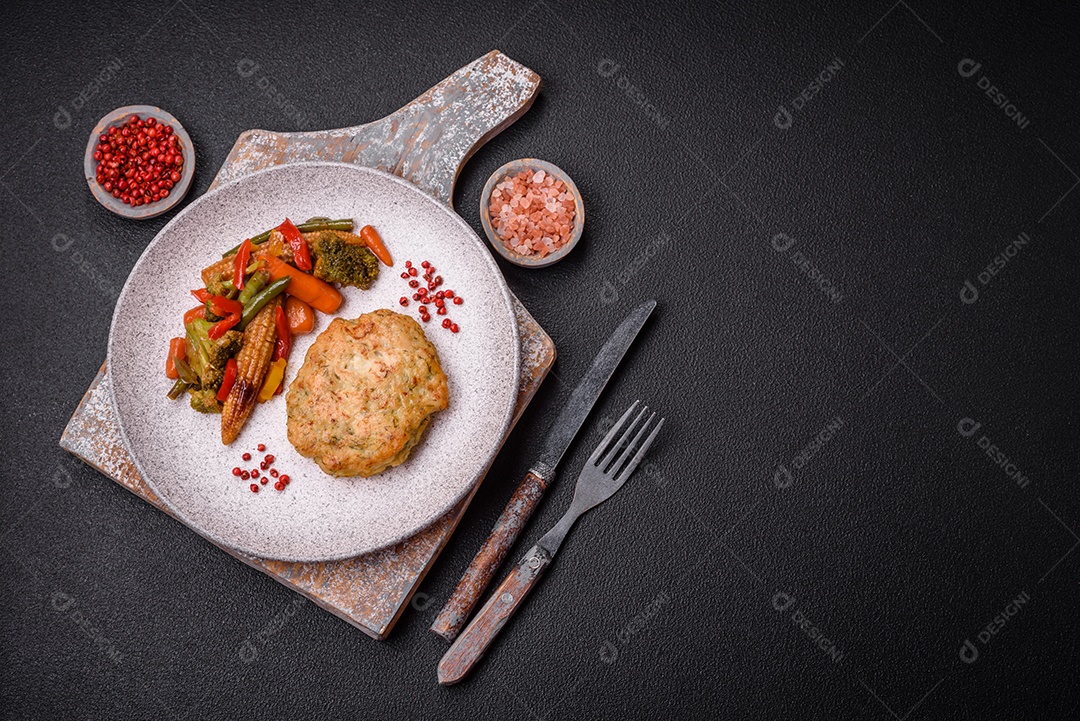 Deliciosas costeletas de peixe picado frito fresco com especiarias e ervas sobre um fundo escuro de concreto