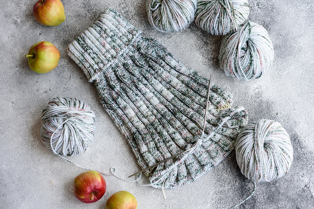 Tricô com agulhas de tricô como ocupação nas horas vagas e hobby. Tricotando café cinza com agulhas de tricô à vontade