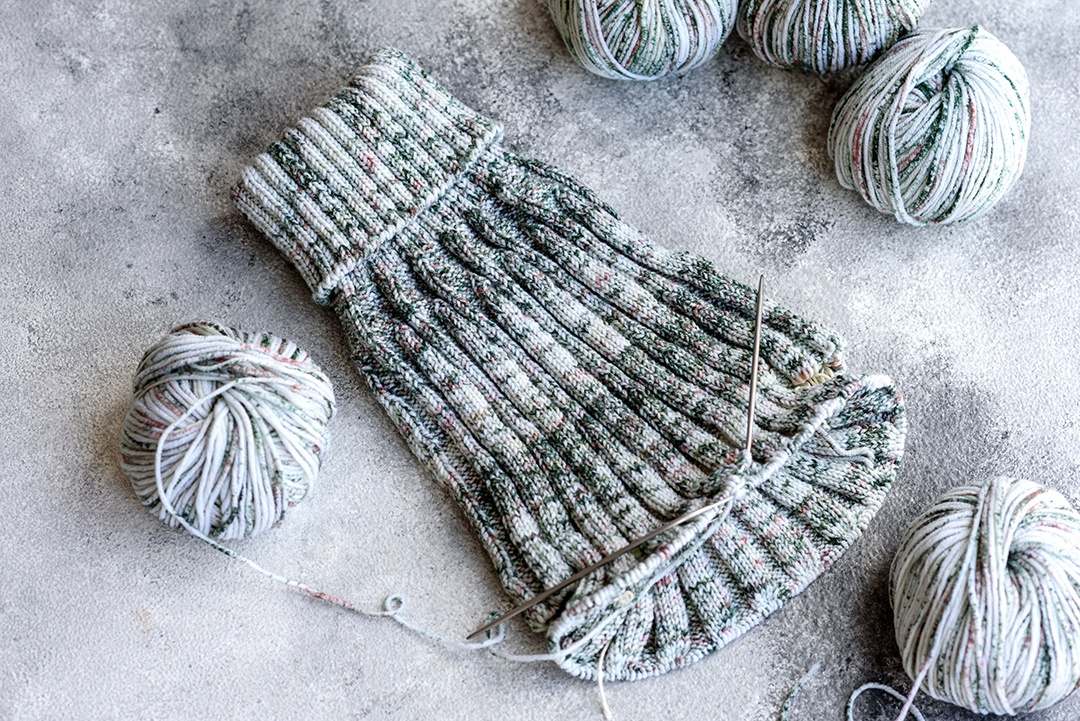 Tricô com agulhas de tricô como ocupação nas horas vagas e hobby. Tricotando café cinza com agulhas de tricô à vontade