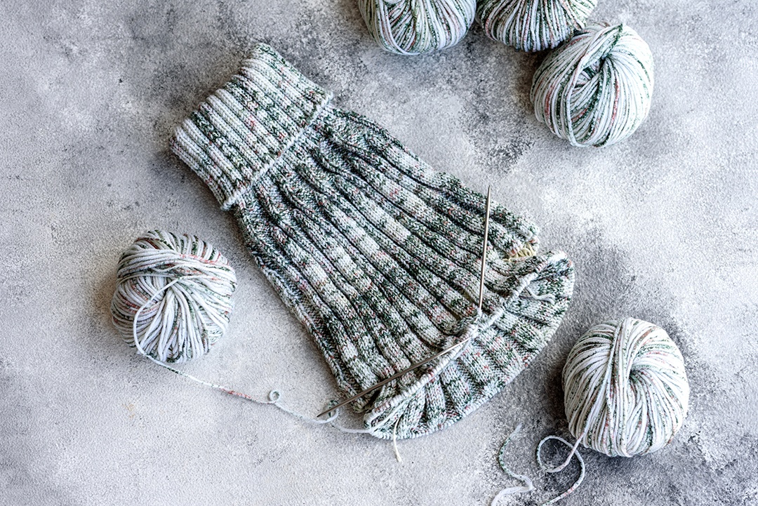 Tricô com agulhas de tricô como ocupação nas horas vagas e hobby. Tricotando café cinza com agulhas de tricô à vontade