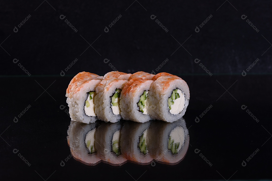 Rolos de sushi lindos e deliciosos frescos em um fundo isolado preto. Elementos da culinária japonesa