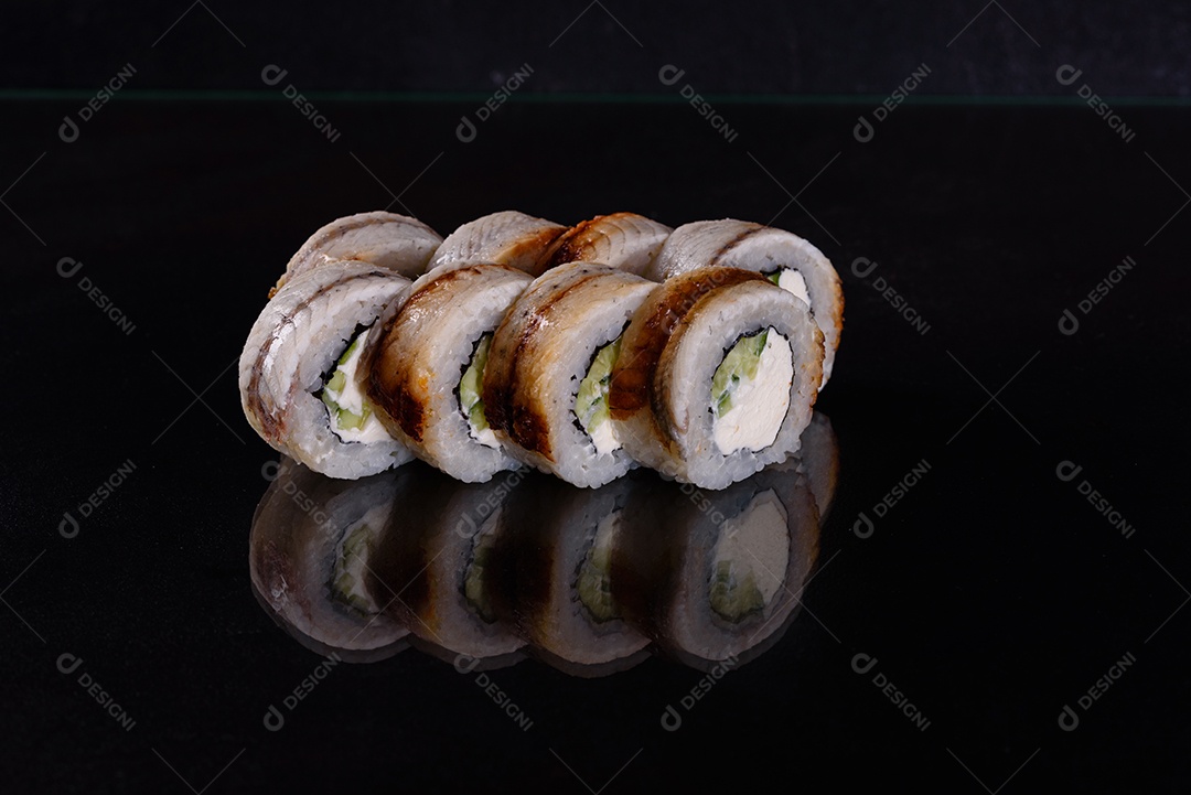 Rolos de sushi lindos e deliciosos frescos em um fundo isolado preto. Elementos da culinária japonesa