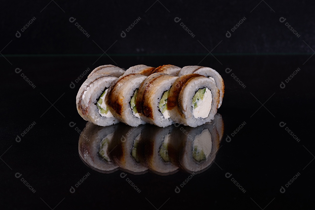 Rolos de sushi lindos e deliciosos frescos em um fundo isolado preto. Elementos da culinária japonesa