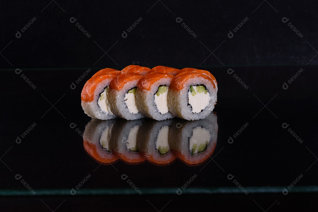Rolos de sushi lindos e deliciosos frescos em um fundo isolado preto. Elementos da culinária japonesa