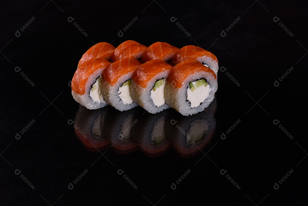 Rolos de sushi lindos e deliciosos frescos em um fundo isolado preto. Elementos da culinária japonesa