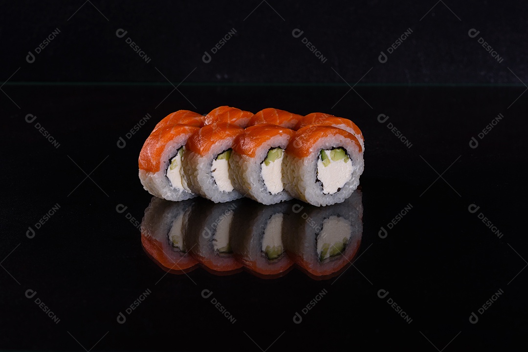Rolos de sushi lindos e deliciosos frescos em um fundo isolado preto. Elementos da culinária japonesa