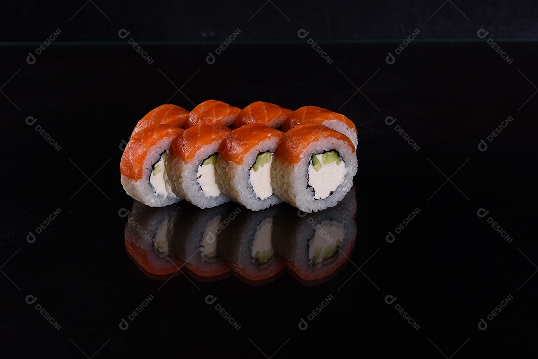 Rolos de sushi lindos e deliciosos frescos em um fundo isolado preto. Elementos da culinária japonesa