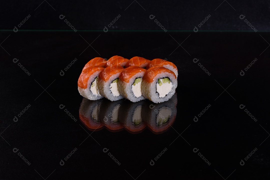 Rolos de sushi lindos e deliciosos frescos em um fundo isolado preto. Elementos da culinária japonesa