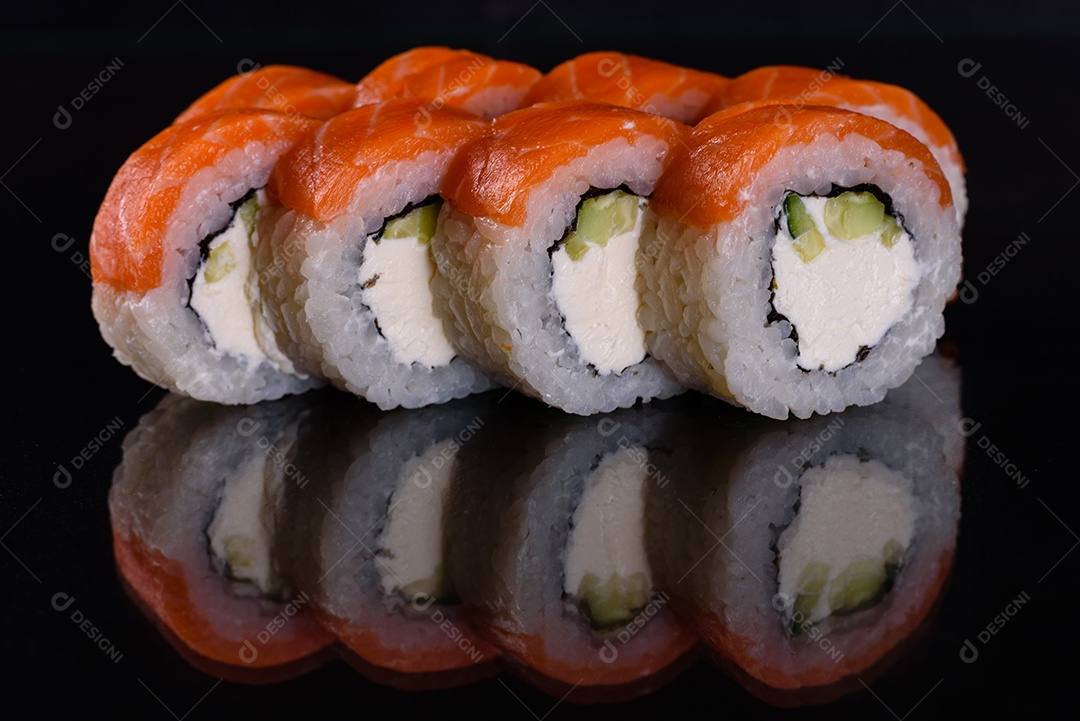 Rolos de sushi lindos e deliciosos frescos em um fundo isolado preto. Elementos da culinária japonesa