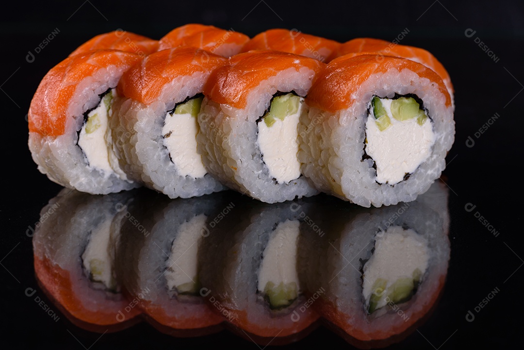 Rolos de sushi lindos e deliciosos frescos em um fundo isolado preto. Elementos da culinária japonesa