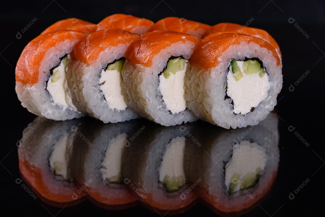 Rolos de sushi lindos e deliciosos frescos em um fundo isolado preto. Elementos da culinária japonesa
