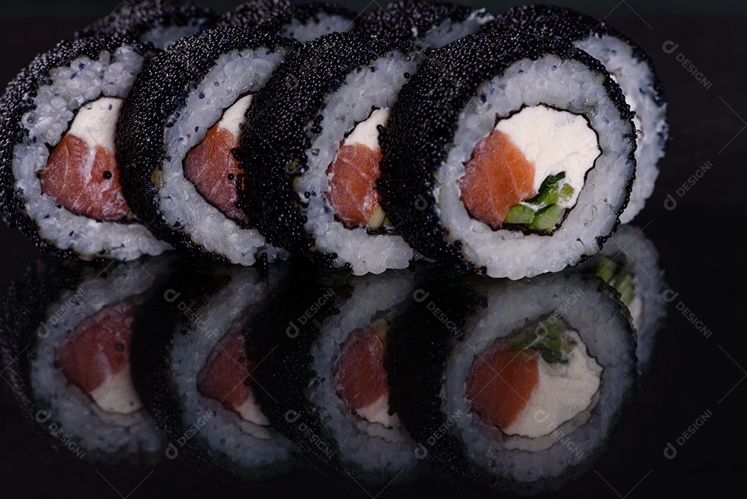 Rolos de sushi lindos e deliciosos frescos em um fundo escuro