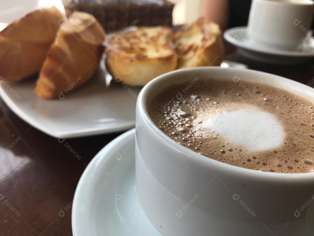 Xícara de café com leite com pães