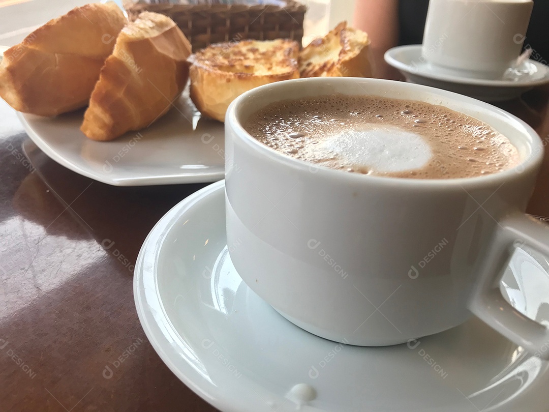 Xícara de café com leite com pães