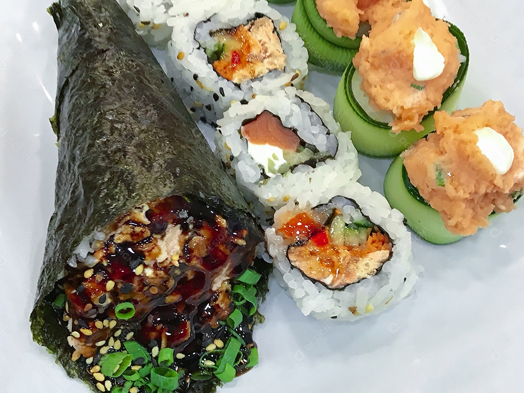 Comida japonesa na mesa: Temaki de salmão, rolinhos de sushi e joe.