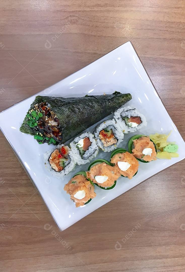 Comida japonesa na mesa: Temaki de salmão, rolinhos de sushi e joe.