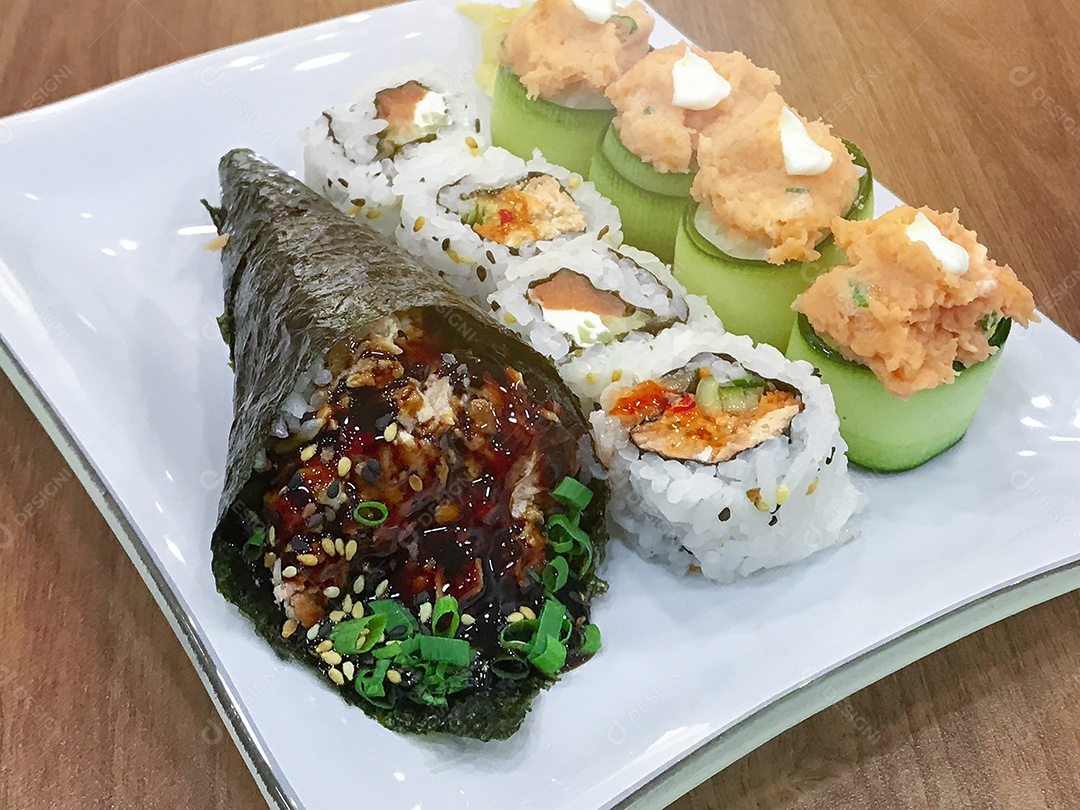 Comida japonesa na mesa: Temaki de salmão, rolinhos de sushi e joe.