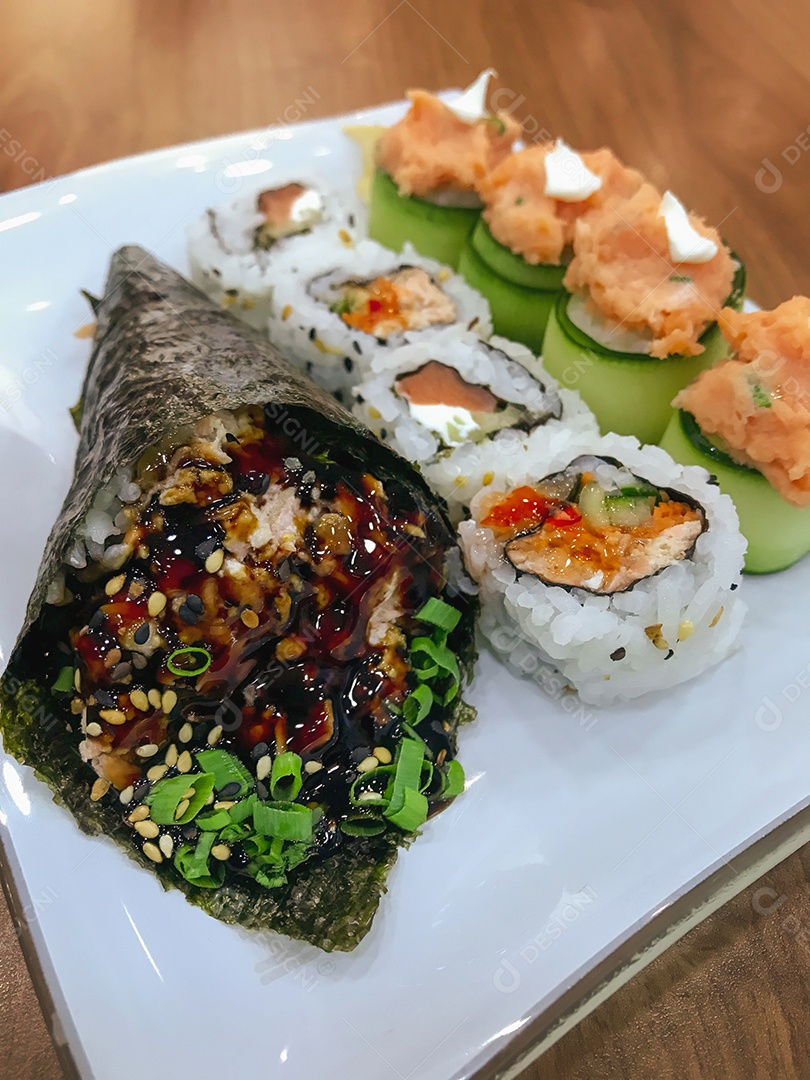 Comida japonesa na mesa: Temaki de salmão, rolinhos de sushi e joe.