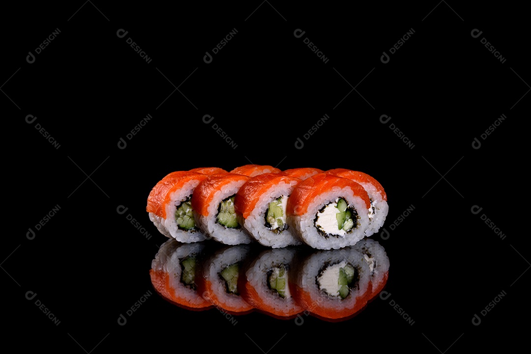 Rolos de sushi lindos e deliciosos frescos em um fundo preto. Elementos da culinária japonesa