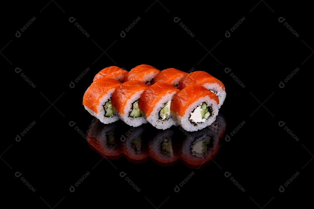 Rolos de sushi lindos e deliciosos frescos em um fundo preto. Elementos da culinária japonesa