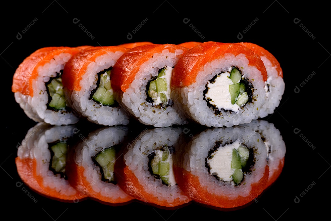 Rolos de sushi lindos e deliciosos frescos em um fundo preto. Elementos da culinária japonesa