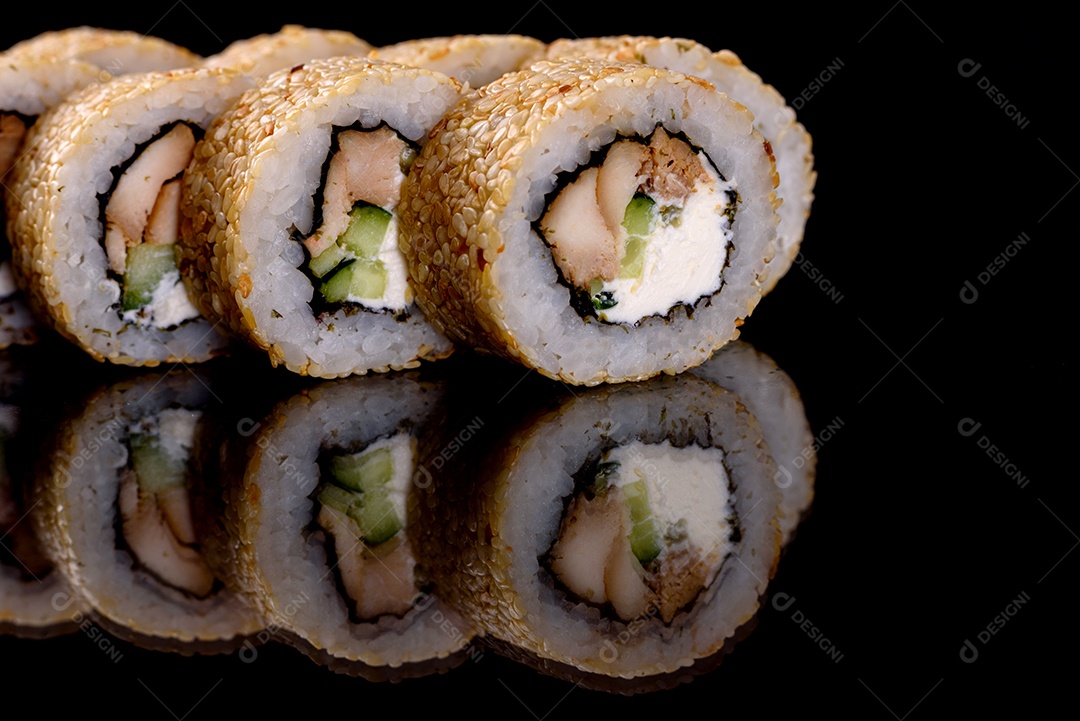 Rolos de sushi lindos e deliciosos frescos em um fundo preto. Elementos da culinária japonesa