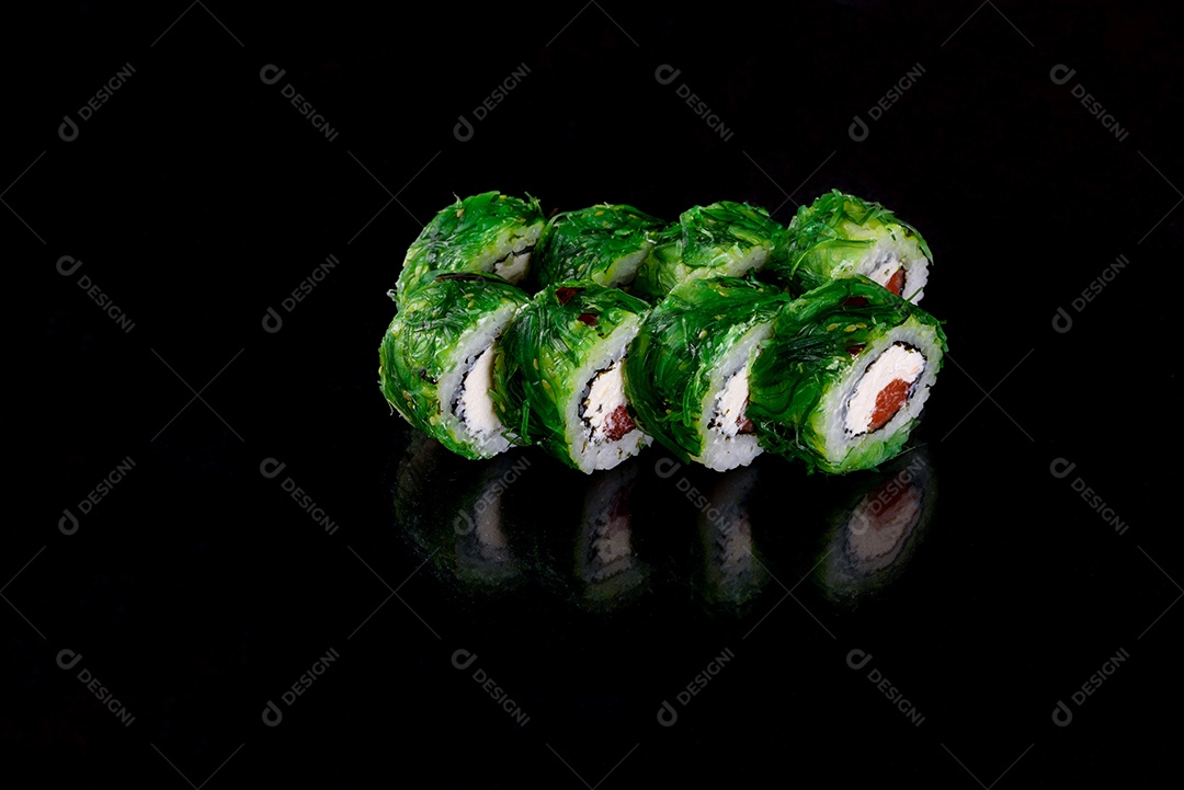 Rolos de sushi lindos e deliciosos frescos em um fundo preto. Elementos da culinária japonesa