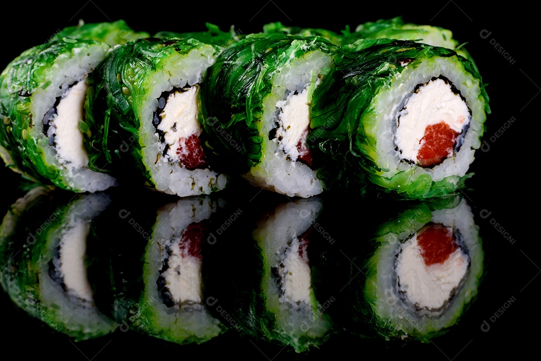 Rolos de sushi lindos e deliciosos frescos em um fundo preto. Elementos da culinária japonesa