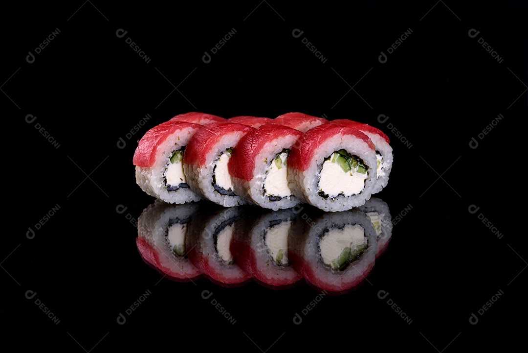 Rolos de sushi lindos e deliciosos frescos em um fundo preto. Elementos da culinária japonesa