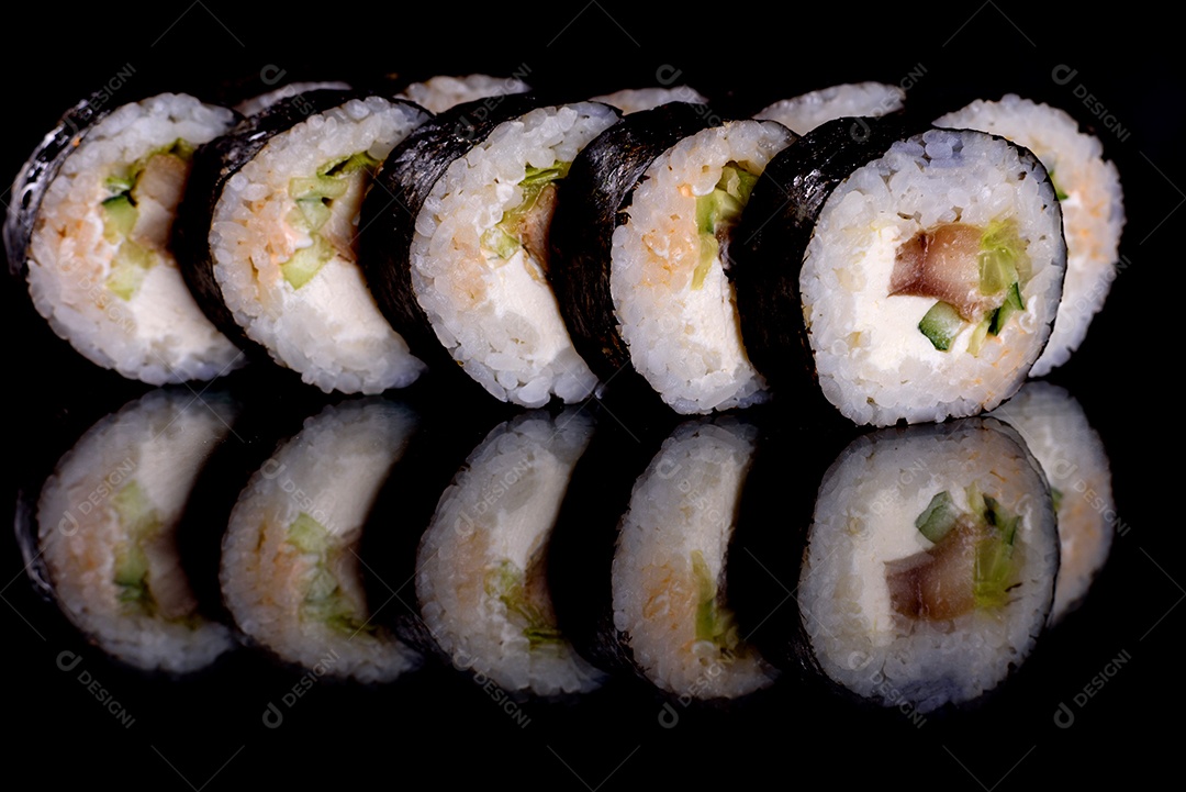 Rolos de sushi lindos e deliciosos frescos em um fundo preto. Elementos da culinária japonesa