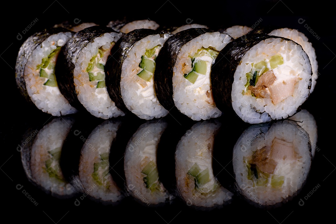 Rolos de sushi lindos e deliciosos frescos em um fundo preto. Elementos da culinária japonesa