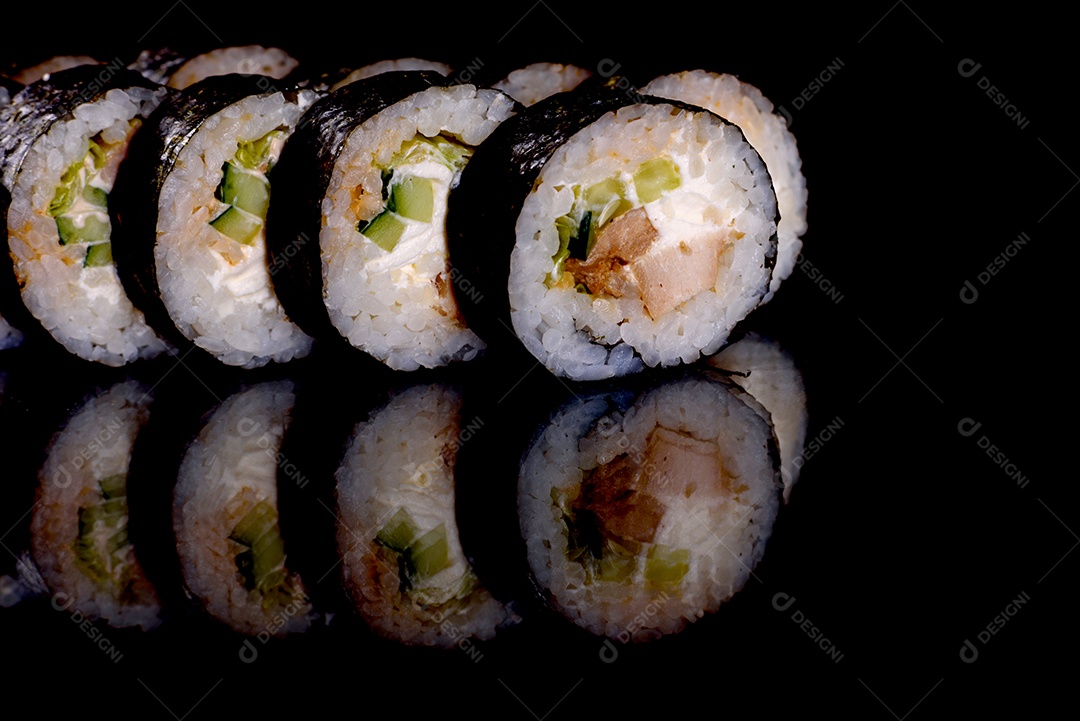 Rolos de sushi lindos e deliciosos frescos em um fundo preto. Elementos da culinária japonesa