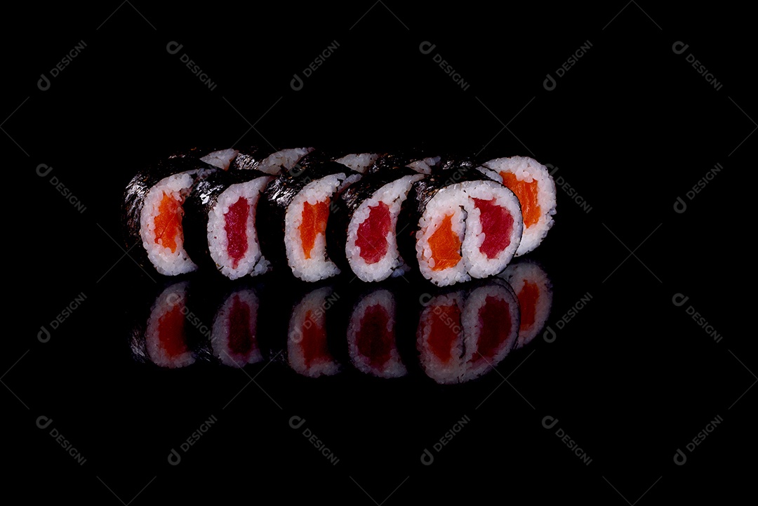 Rolos de sushi lindos e deliciosos frescos em um fundo preto. Elementos da culinária japonesa