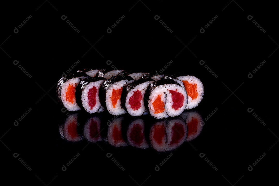 Rolos de sushi lindos e deliciosos frescos em um fundo preto. Elementos da culinária japonesa