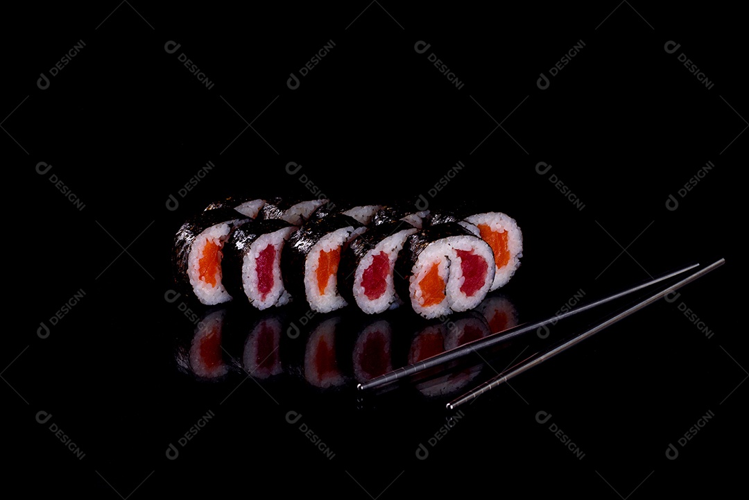 Rolos de sushi lindos e deliciosos frescos em um fundo preto. Elementos da culinária japonesa