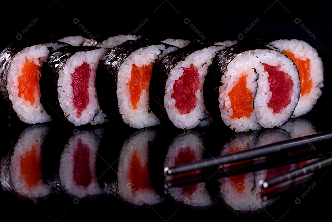Rolos de sushi lindos e deliciosos frescos em um fundo preto. Elementos da culinária japonesa
