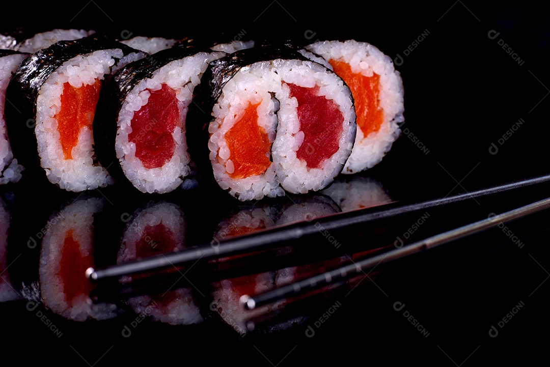 Rolos de sushi lindos e deliciosos frescos em um fundo preto. Elementos da culinária japonesa