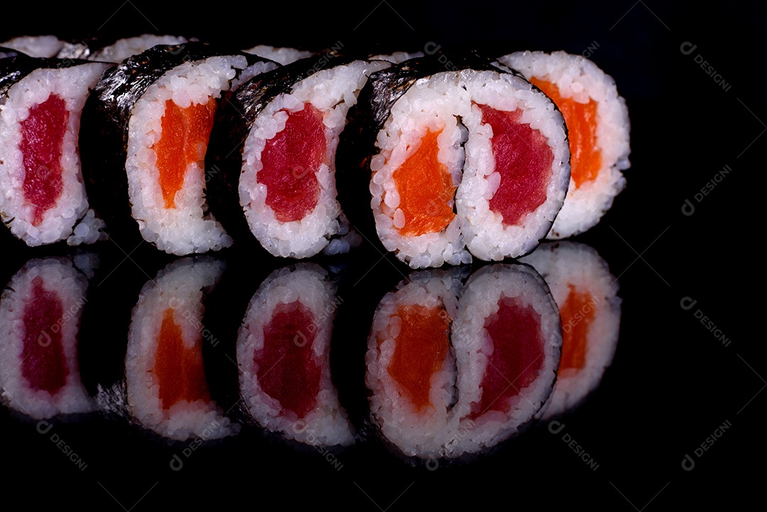 Rolos de sushi lindos e deliciosos frescos em um fundo preto. Elementos da culinária japonesa