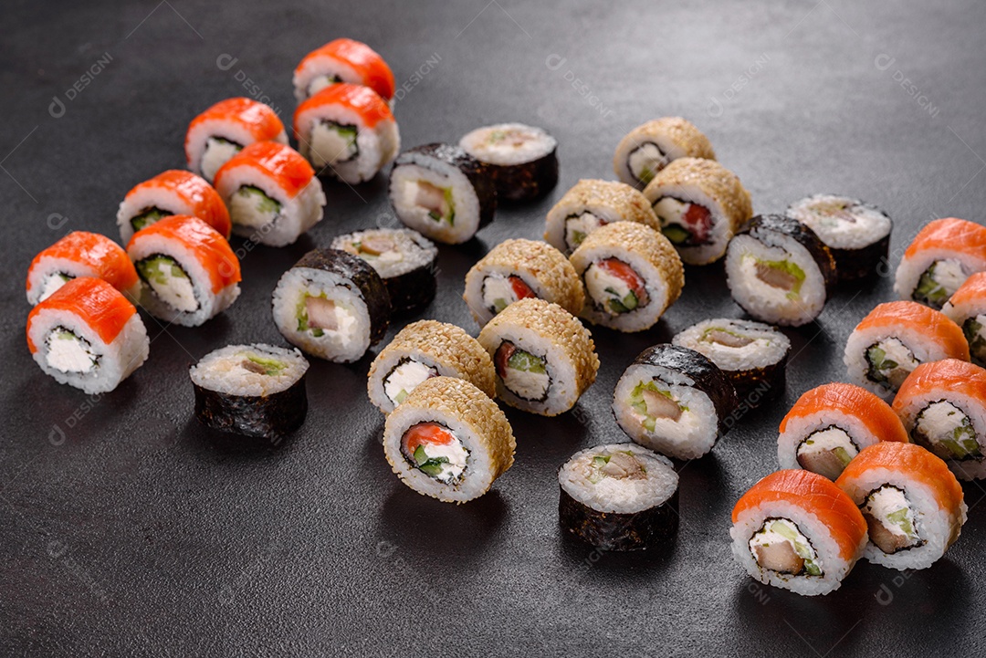 Rolos de sushi lindos e deliciosos frescos em um fundo preto. Elementos da culinária japonesa