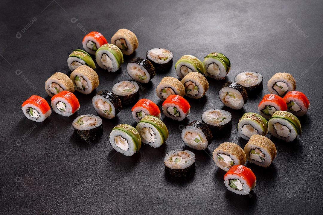 Rolos de sushi lindos e deliciosos frescos em um fundo preto. Elementos da culinária japonesa