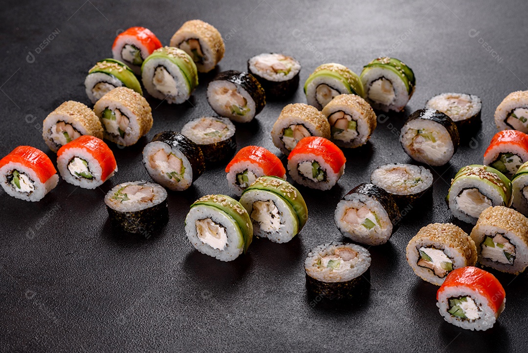 Rolos de sushi lindos e deliciosos frescos em um fundo preto. Elementos da culinária japonesa