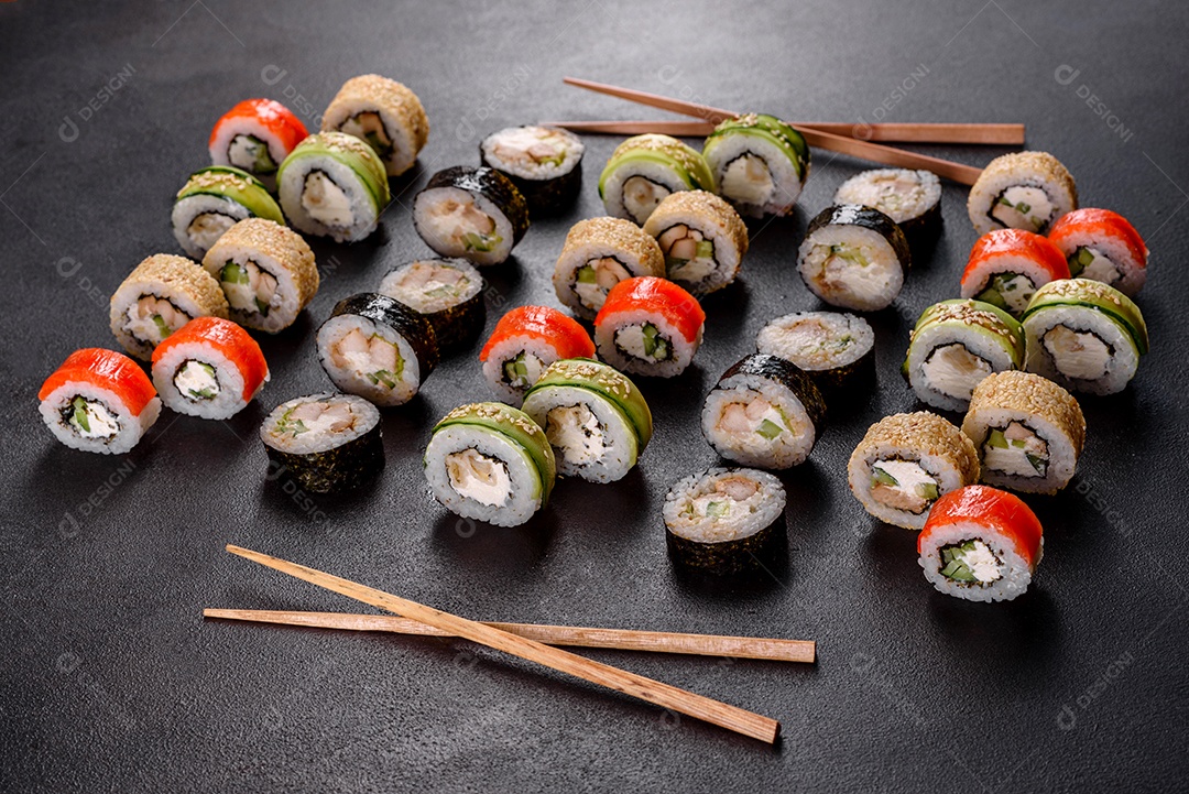 Rolos de sushi lindos e deliciosos frescos em um fundo preto. Elementos da culinária japonesa