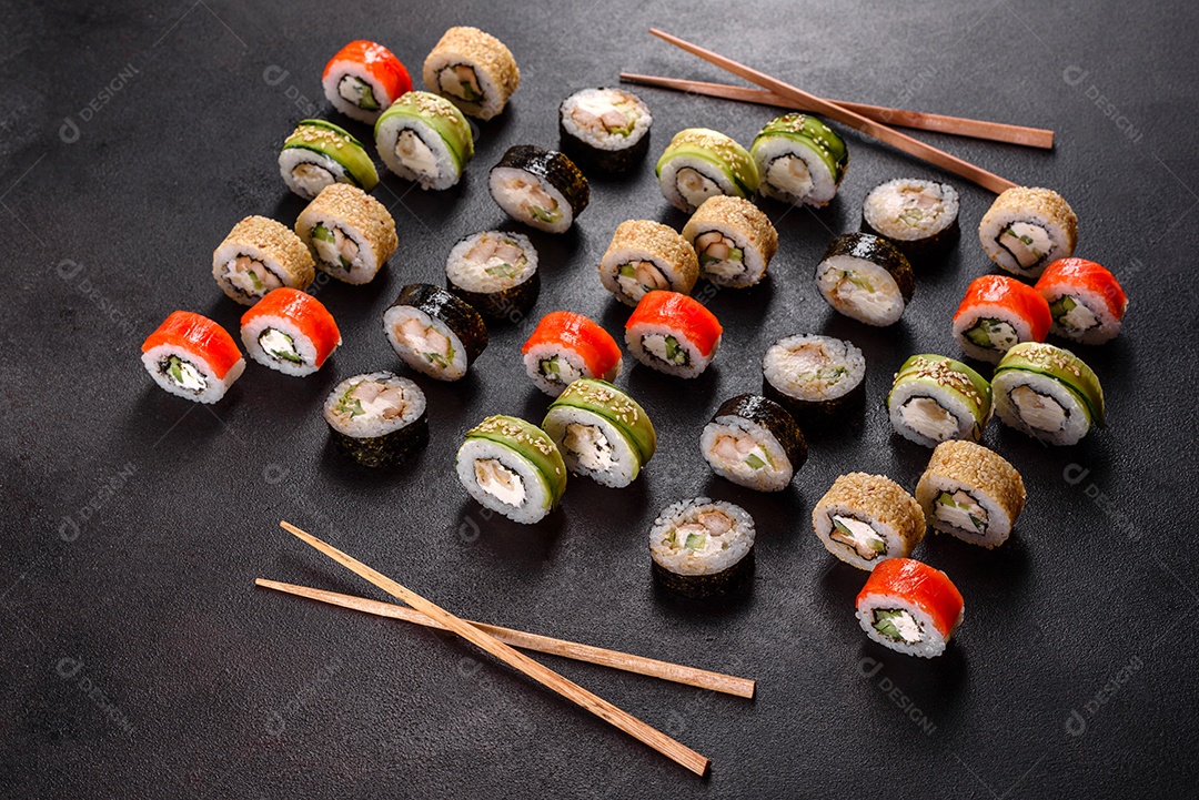 Rolos de sushi lindos e deliciosos frescos em um fundo preto. Elementos da culinária japonesa