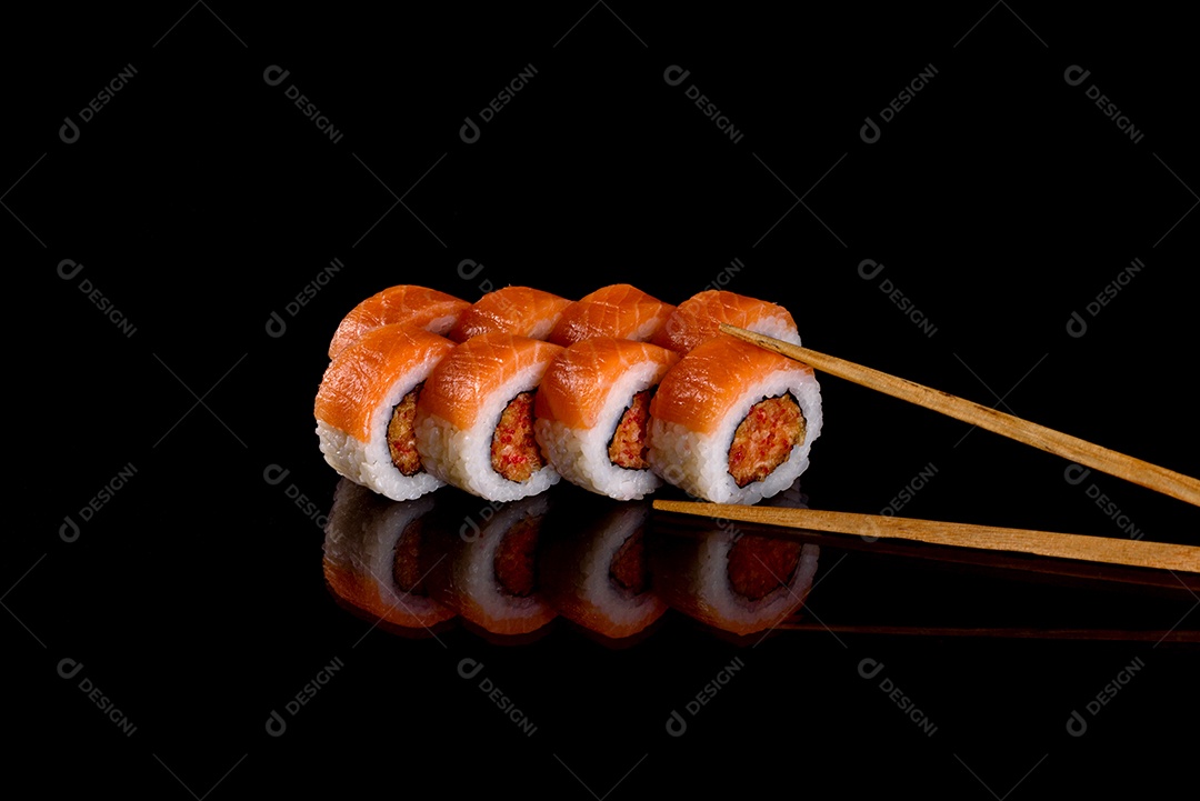 Rolos de sushi lindos e deliciosos frescos em um fundo preto. Elementos da culinária japonesa