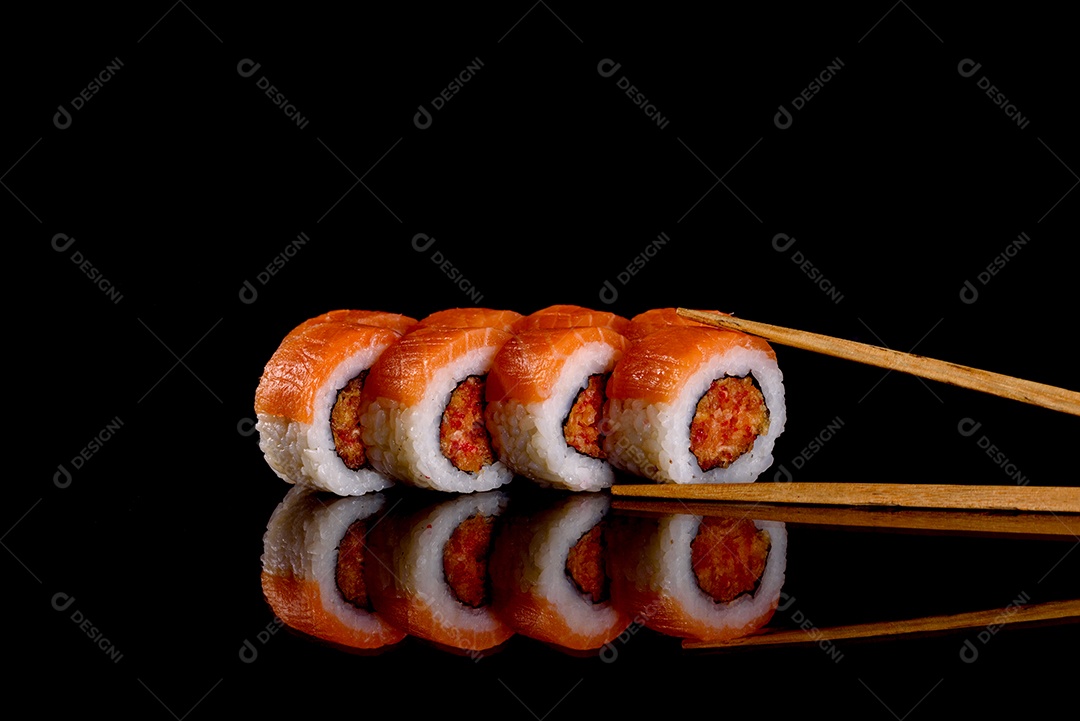 Rolos de sushi lindos e deliciosos frescos em um fundo preto. Elementos da culinária japonesa