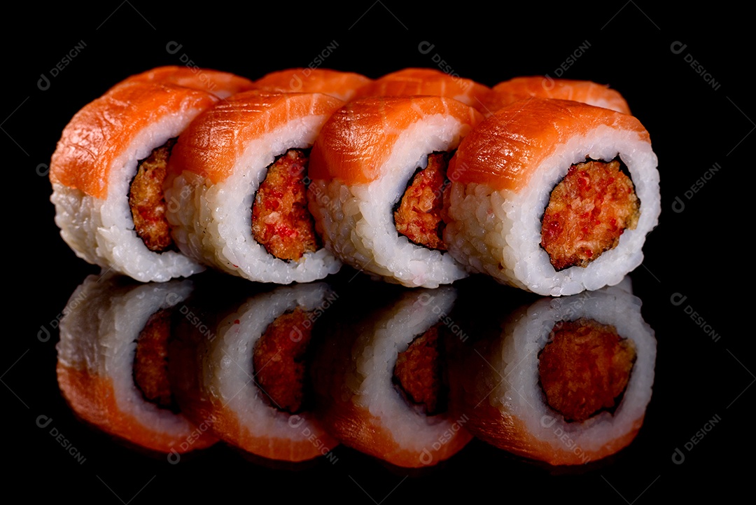 Rolos de sushi lindos e deliciosos frescos em um fundo preto. Elementos da culinária japonesa