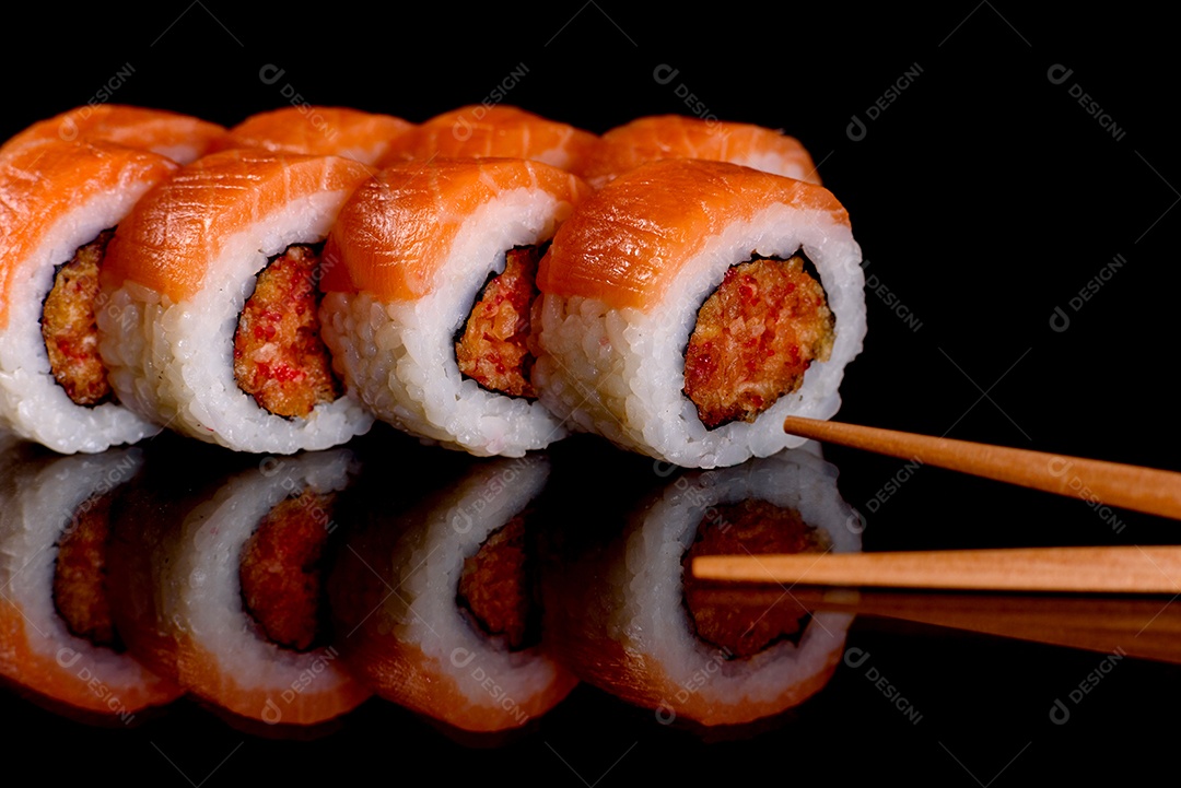 Rolos de sushi lindos e deliciosos frescos em um fundo preto. Elementos da culinária japonesa
