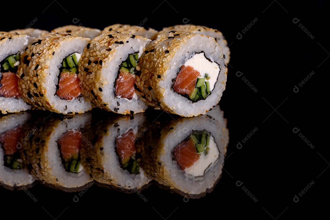 Rolos de sushi lindos e deliciosos frescos em um fundo preto. Elementos da culinária japonesa